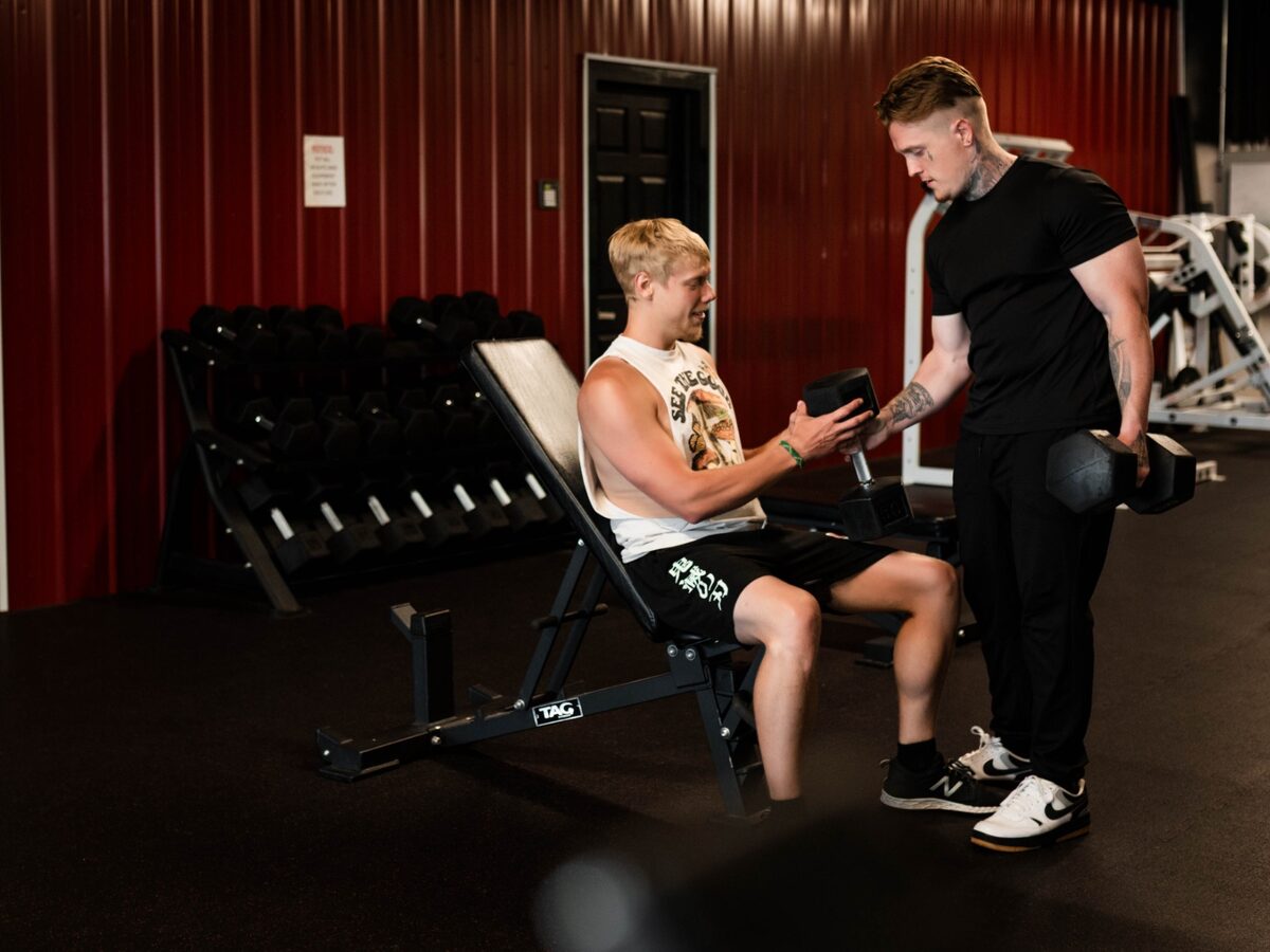 Jacob coaching a client during a dumbbell exercise